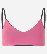 Top deportivo reversible en microfibra doble faz, color rosa con tiras grises. Tiene escote en V, breteles finos paralelos y copas removibles.