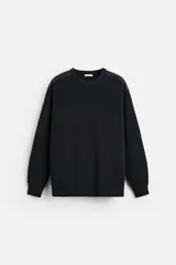 Sweater negro de punto con cuello redondo y manga larga. Presenta parches combinados a tono en hombros y codos.