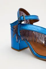 Sandalias de gamuza azul con taco cuadrado y tiras con flecos azules.