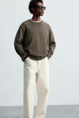 Pantalón de jean negro de corte amplio y tiro alto, con cinco bolsillos y cierre frontal con botón.