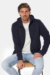 Canguro con cierre y capucha color bordó, confeccionado en felpa de algodón y poliéster.