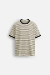 Camiseta a rayas horizontales color crema con cuello redondo y mangas cortas con ribete negro.