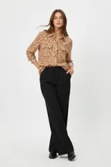 Camisa de viscosa con estampado floral en tonos tierra, cuello clásico, cierre frontal con botones y dos bolsillos delanteros con solapa.