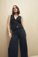 Pantalón de jean negro de corte ancho, tiro medio y cinco bolsillos.