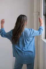 Camisa celeste de lino con botones, corte holgado y mangas largas con puños abotonados.