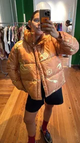 Campera puffer color camel con estampado de cachemir y figuras geométricas en amarillo pálido.