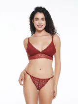Conjunto de ropa interior color bordó de encaje, compuesto por un bralette de encaje con breteles finos y una tanga de encaje con laterales finos.