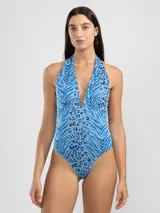 Malla enteriza con estampado animal print en tonos celeste y azul. Diseño halter con escote en V profundo. Confeccionada con tejido jacquard de poliamida y elastano con protección UV50 y resistencia al cloro, protectores solares y aceites.