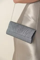 Cartera de mano plateada de lurex con frente plisado y cadena metálica para colgar.