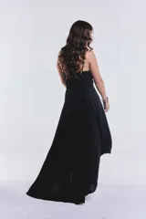 Vestido negro largo irregular con breteles finos y escote en V.