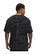Remera de hombre Under Armour Project Rock, de corte holgado y manga corta, con estampado de camuflaje en tonos negro y marrón.