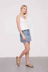 Musculosa blanca de breteles finos con detalles de encaje en el escote y bordado calado en el cuerpo.