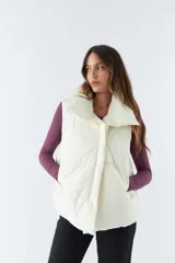 Chaleco blanco con cuello alto y bolsillos laterales.