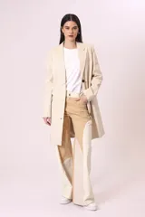 Blazer largo color beige, de corte recto y solapas clásicas.