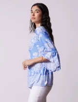 Blusa azul con estampado floral blanco, de seda fría, con cuello redondo con abertura y mangas 3/4 amplias con volados. Marca Ruby Rd.