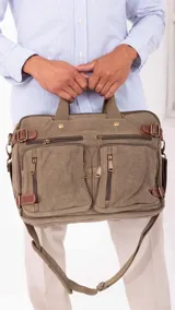 Mochila de tela canvas color beige con detalles en cuero marrón. Cuenta con múltiples bolsillos con cierre, compartimento acolchado para notebook y correas ajustables.