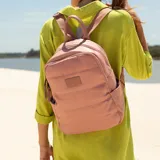Mochila capitoneada color rosa, confeccionada en nylon. Tiene apertura superior con cierre y tiradores metálicos, bolsillos internos, bolsillo frontal con cierre metálico, correa corta de mano y correas de galón regulables para colgar en la espalda.