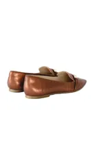 Mocasines color bronce metalizado con punta fina y detalle de hebilla dorada.