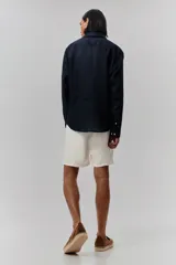 Short blanco de lino y algodón, con corte relajado, cintura elástica con cordón ajustable, bolsillos laterales y bolsillo trasero insertado.
