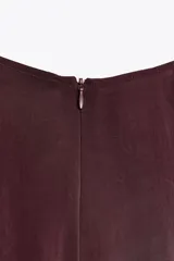 Vestido midi negro de cuello redondo y sin mangas. Corte amplio y fluido, con bolsillos laterales ocultos y cierre trasero con cremallera invisible.
