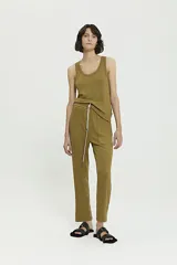 Conjunto de top musculosa y pantalón babucha de morley de viscosa color ocre. El top es de corte clásico y el pantalón tiene tiro medio, largo al tobillo, cintura con elástico interno y cordón de algodón con terminales metálicas, bolsillo plaqué y detalle de cartera falsa en frente.
