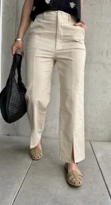 Pantalón color beige de lino, corte recto con abertura en el ruedo.