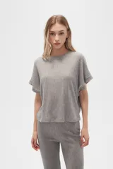 Remera gris de poliéster y lurex, manga corta, corte holgado y cuello a la base.