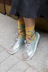 Championes celestes con glitter multicolor en punta y talón, lazo de raso y suela de cuero.