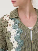 Chaleco tejido a crochet con diseño de flores en tonos beige y crudo, con cuello camisero y cierre frontal con botones de madera.