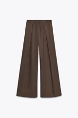 Pantalón marrón de lino, de tiro medio, corte palazzo, cintura elástica ajustable con cordones y bolsillos laterales.
