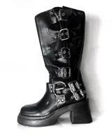 Bota negra de caña media con plataforma y taco cuadrado. Presenta múltiples correas con hebillas metálicas plateadas.