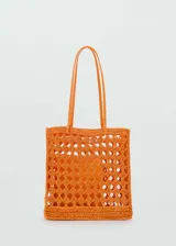 Bolso shopper naranja de fibra natural con diseño calado y doble asa fina.