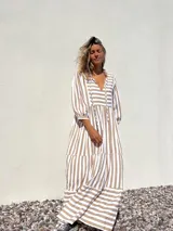 Vestido largo tipo túnica con rayas verticales color beige y crudo, escote en V con lazos y mangas 3/4.