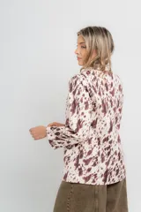 Blazer de corte clásico con estampado de vaca en tonos marrón y blanco.