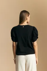 Remera negra de manga corta con mangas abullonadas y cuello redondo.