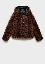 Chaqueta corta negra efecto cuero, con capucha y forro de animal print. Tiene bolsillos de parche delanteros y cierre con botones. Es reversible y de corte oversize.
