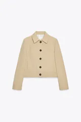 Chaqueta color beige de cuello solapa y manga larga con hombreras acabada en puño. Presenta bolsillos laterales y falso bolsillo de vivo en pecho. Cierre frontal con botones.