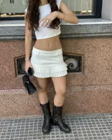 Minifalda blanca con pretina lisa y ruedo con pliegues anchos.