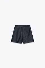 Minifalda pantalón de tiro alto confeccionada en denim azul oscuro. Presenta una abertura delantera y cierre lateral con cremallera oculta.