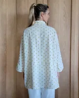 Camisa celeste de corte amplio, con cuello clásico y mangas largas.