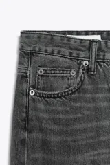 Jeans de tiro alto con pierna ancha y largo completo. Confeccionados en tejido rígido con cinco bolsillos, cintura con trabillas, detalle de costuras torcidas y cierre con cremallera y botón metálico.