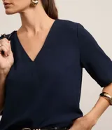 Blusa roja de crepé con escote en V, mangas cortas y corte holgado.