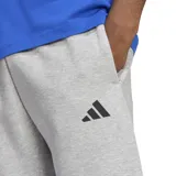 Pantalón de jogging gris con cintura ajustable y logo de Adidas en la pierna izquierda. Presenta tres tiras negras en la parte inferior de ambas piernas.