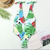 Traje de baño enterizo con estampado abstracto multicolor, escote en V y tirantes finos con lazos en los hombros.