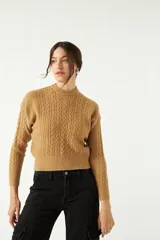 Sweater color camel de punto con diseño de ochos en el frente y mangas, cuello semi alto y corte al cuerpo.