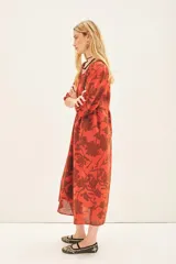 Vestido midi color ladrillo con estampado floral marrón, escote en V, mangas 3/4 abullonadas y cinturón con aplique de flor.