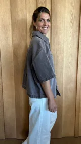 Sobrecamisa color gris oscuro de denim suave, con cuello clásico, cierre frontal con botones, mangas cortas y dos bolsillos de parche en el pecho.