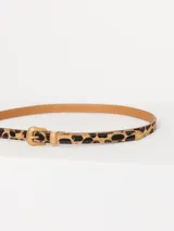 Cinturón delgado de cuero con estampado animal print y hebilla metálica dorada.