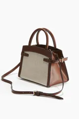 Cartera bandolera de lona color crudo con detalles en cuero marrón. Tiene doble asa corta y correa larga ajustable y extraíble.