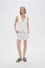 Short blanco de lino, de tiro alto y corte holgado.